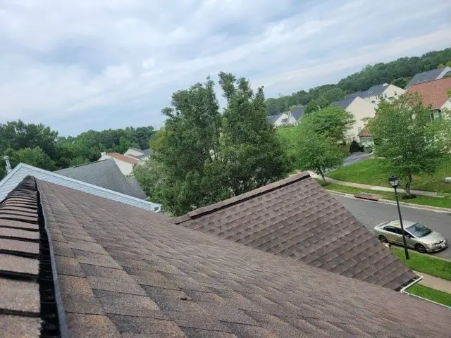 Completed shingle roof with finished ridge cap and hip lines overlooking a Laurel, MD neighborhood