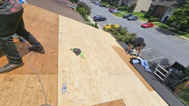 Residential roof replacement in progress with new plywood sheathing and roofing crew on site in Laurel, MD