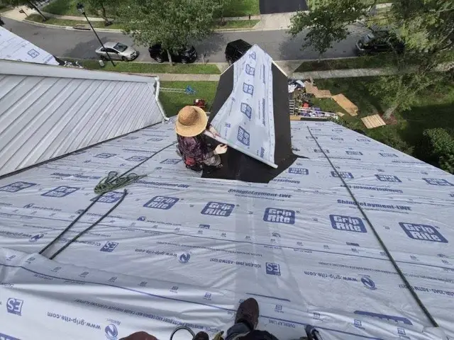Roofer fitting synthetic underlayment around a dormer during a roof replacement in Laurel, MD