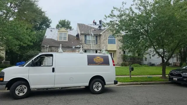 Sunrise Construction Services van parked outside a Laurel, MD home while the crew replaces the roof
